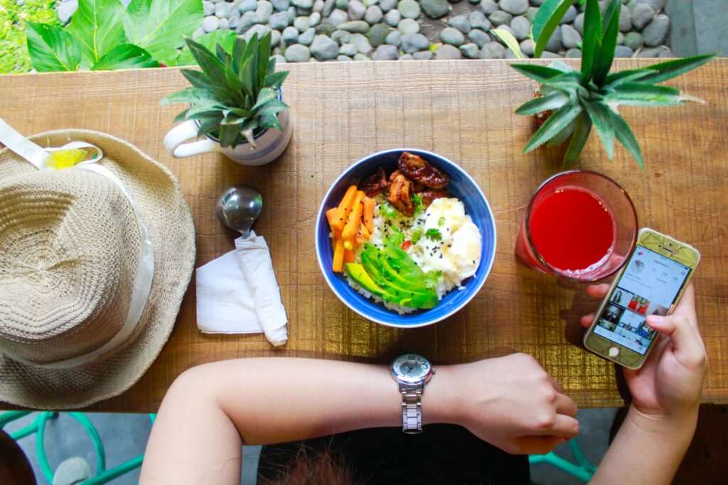 Fresh and healthy bowl meal with juice and smartphone on a wooden table, perfect for lifestyle and food photography.