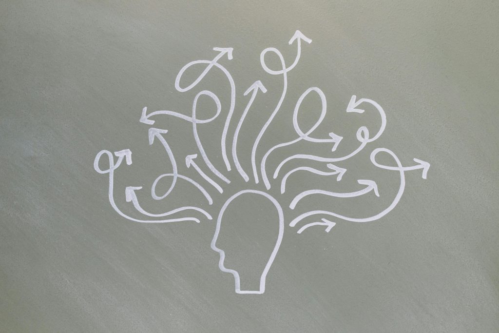 Conceptual chalk drawing illustrating mental health challenges with arrows representing thoughts.